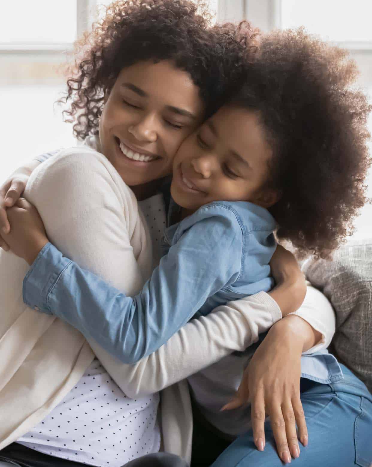 African American mother and daughter embracing in a loving hug
