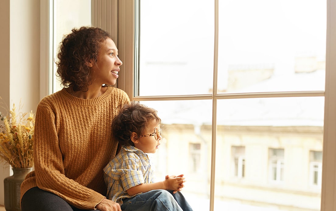 Mother and son looking out the window at the city buildings
