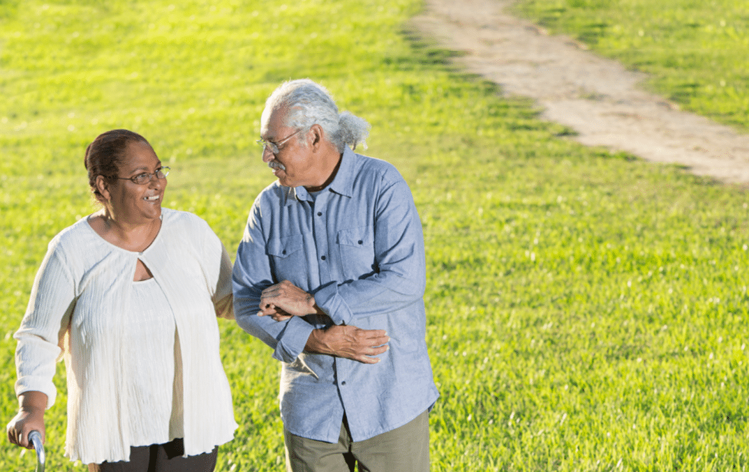 Two seniors walking in the park talking pleasantly