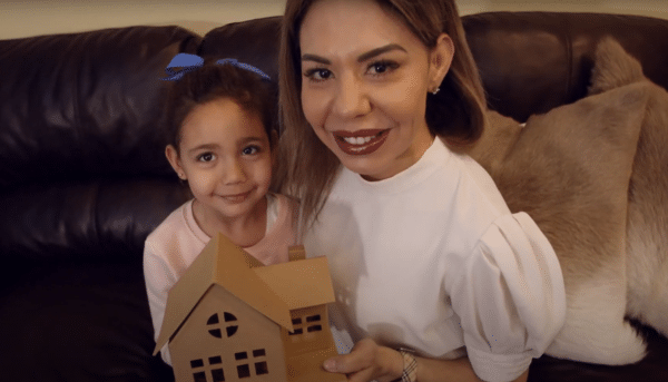 Young family of mom and dad holding young boy and girl in their arms wearing masks